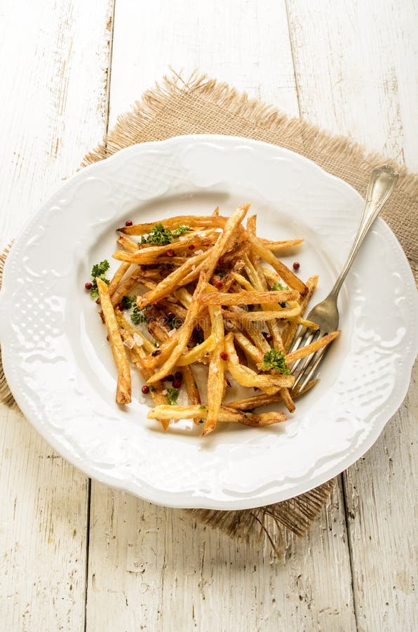 French Fries with Salt, Red Peppercorn and Parsley on a Plate Stock ...