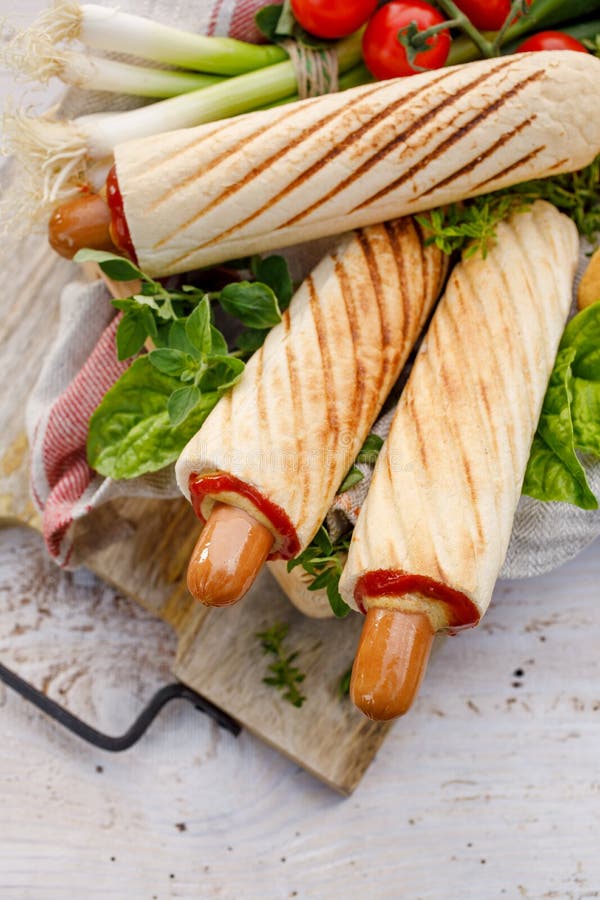 Hot-dog francezi cu ketchup și muștar delicios pe stradă royalty free stock photo