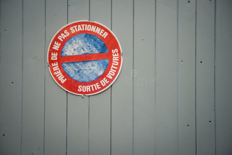 French 'Defense De Stationner - Sortie De Voitures' (No Parking - Car Exit)  sign on garage doors Stock Photo - Alamy