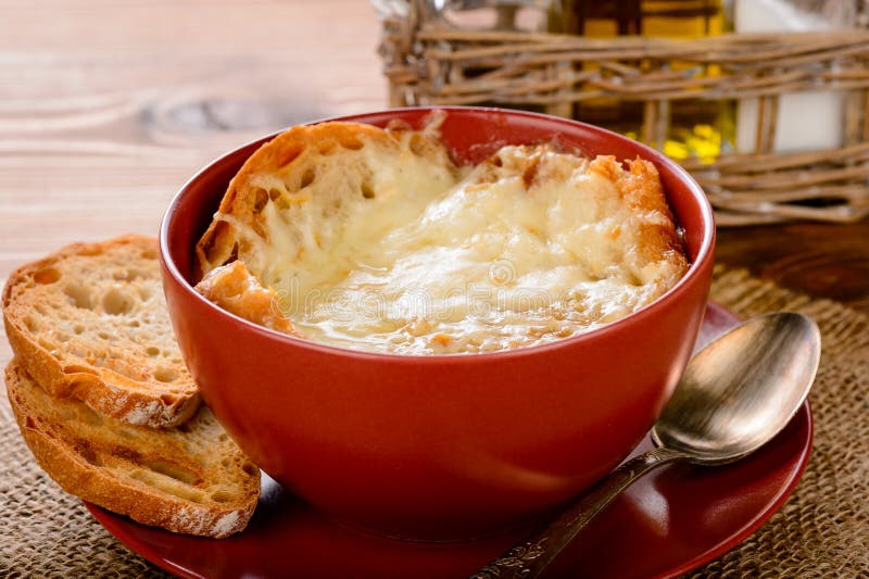 French onion soup with toasts on wooden table.