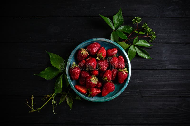 Fresas frescas en una placa contra fondo negro imágenes de archivo libres de regalías Fresas frescas en una placa contra fondo negro imágenes de archivo libres de regalías