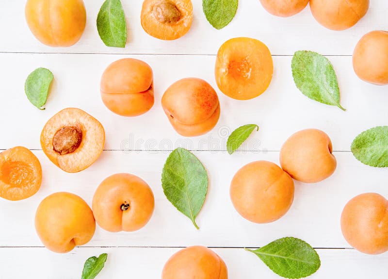 Fresh apricot pattern on white wooden background with leaves flat lay top view royalty free stock photography