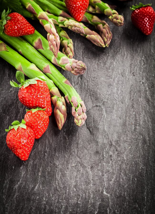 Fresh asparagus spears and ripe red strawberries