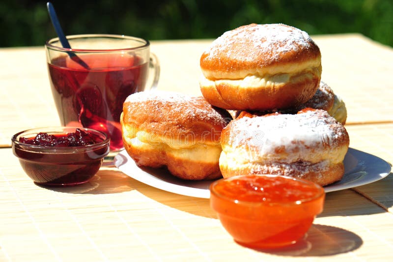 Fresh baked donuts with fruit jam and tea