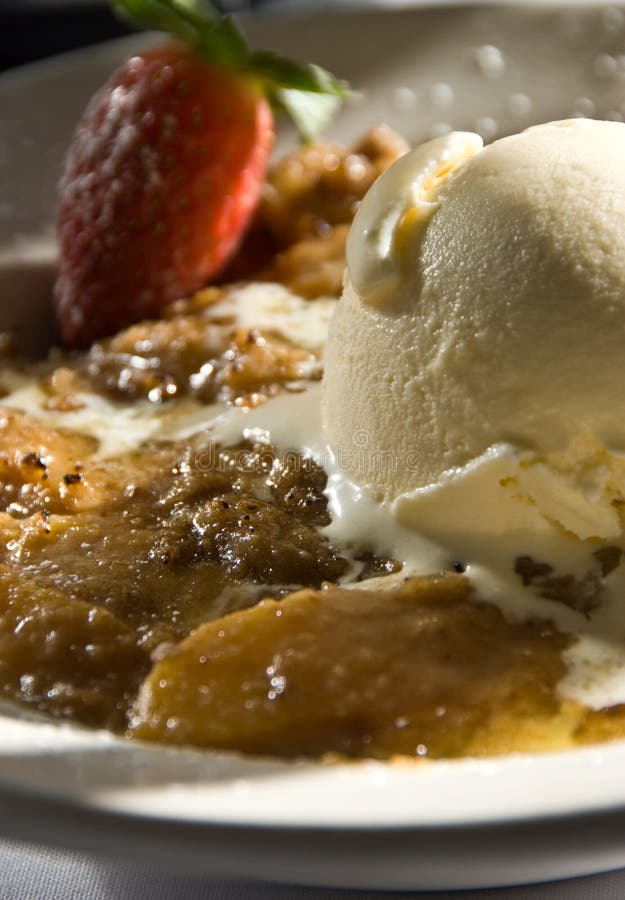 Fresh baked peach cobbler with strawberries and ice cream