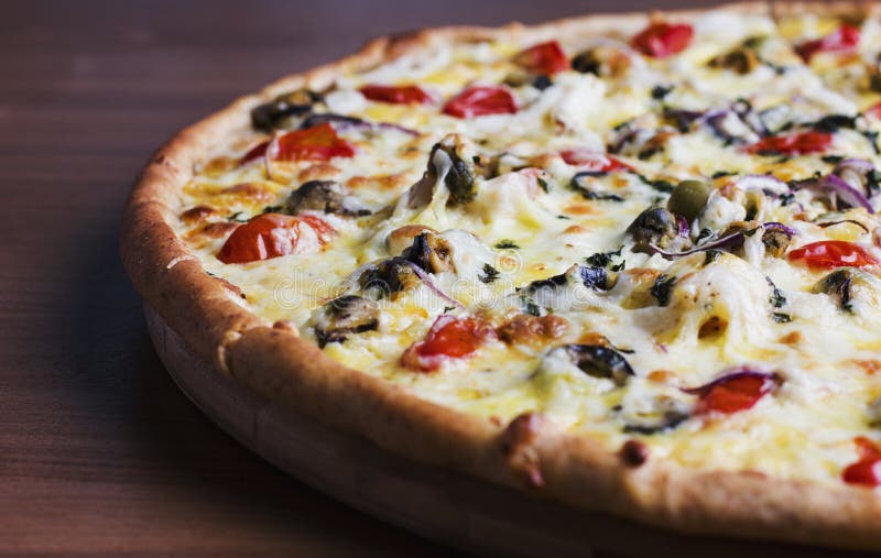 The fresh baked pizza with olives and tomatoes