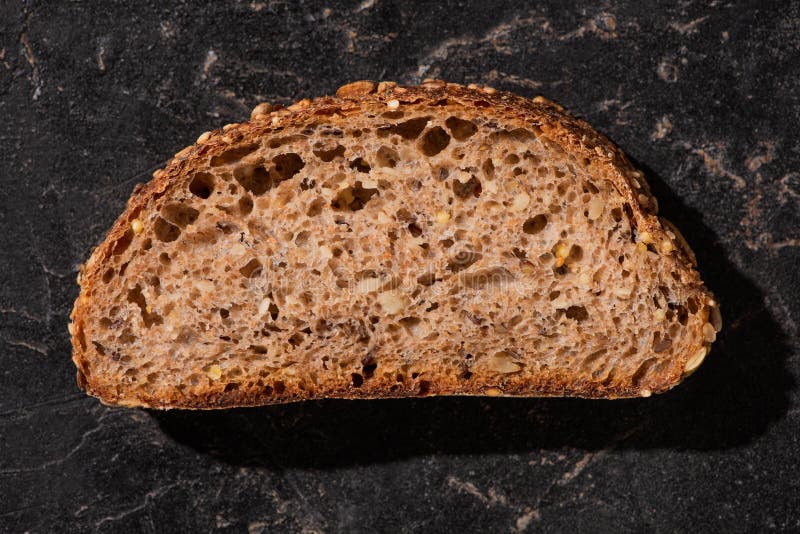 Fresh Baked Whole Grain Bread Slice on Stone Black Surface Stock Image