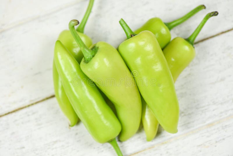 Fresh banana peppers or sweet pepper green garden on a white wooden background - Capsicum annuum