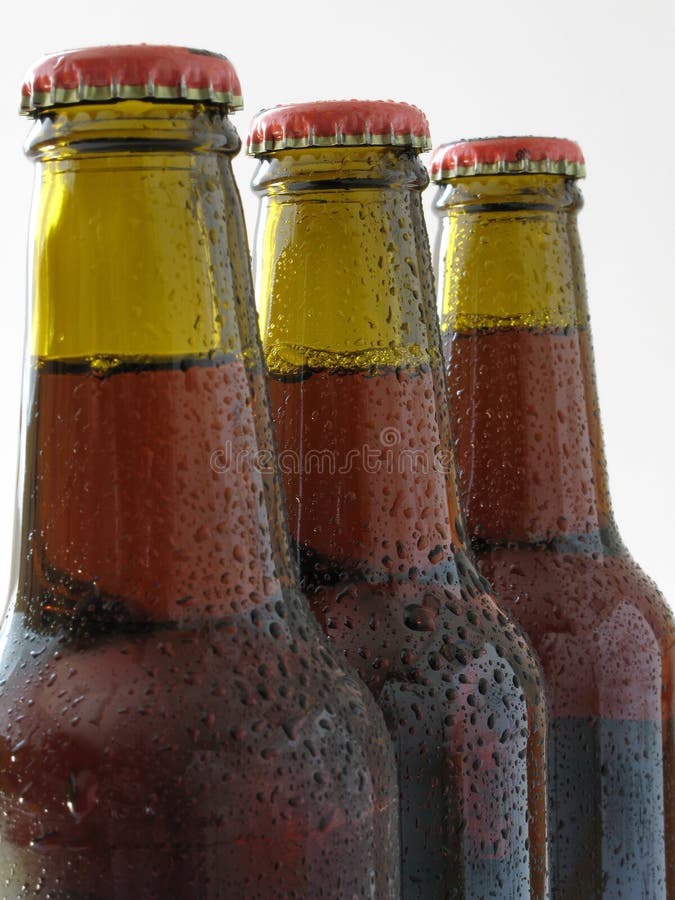 Tři lahve čerstvého piva s víčky zaměřit na druhou láhev.