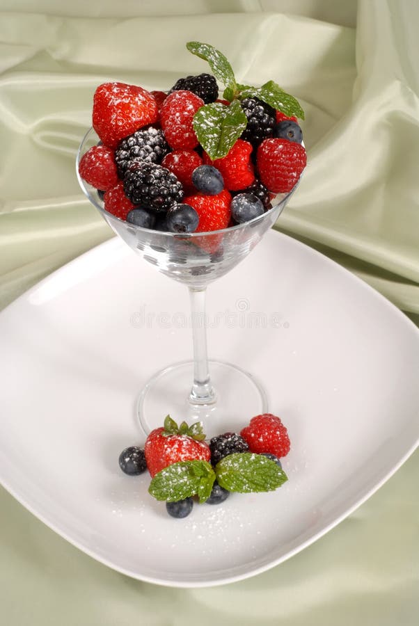 Fresh berries topped with mint and powdered sugar in and around