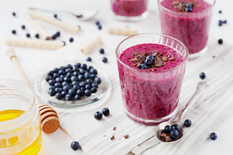 Fresh berry smoothie, milkshake, yogurt, dessert decorated grated chocolate, honey and blueberry