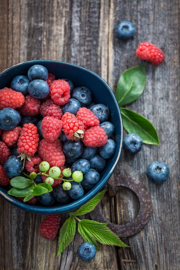 Fresh blueberries and raspberries in dark blue bowl stock photography Fresh blueberries and raspberries in dark blue bowl stock photography