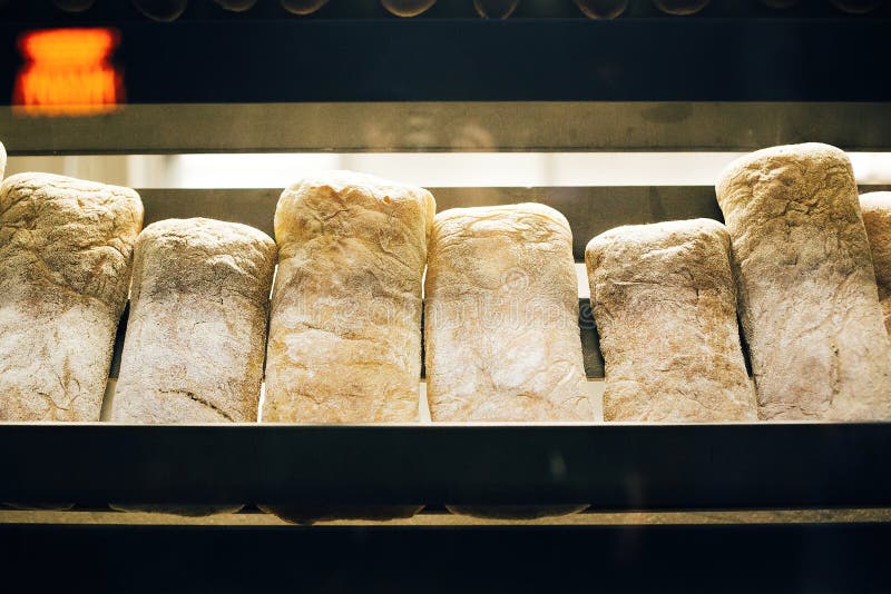 Fresh bread on shelves stand of a shop or bakery. Freshly baked bread loaves at window of store front. Organic pastry. Space for royalty free stock photo Fresh bread on shelves stand of a shop or bakery. Freshly baked bread loaves at window of store front. Organic pastry. Space for royalty free stock photo