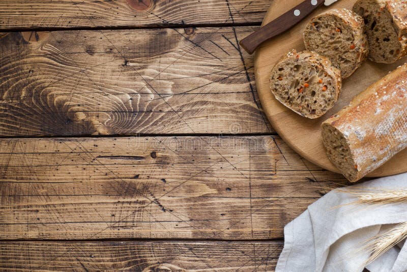 Fresh bread with sunflower seeds, sesame seeds and flax are cut into pieces on a cutting board. Wooden background, copy space stock photos Fresh bread with sunflower seeds, sesame seeds and flax are cut into pieces on a cutting board. Wooden background, copy space stock photos