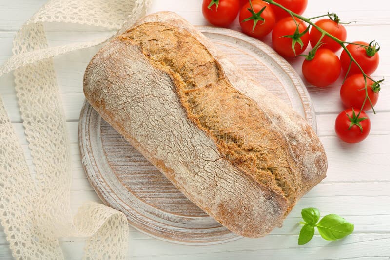Fresh bread on a wooden board and tomatoes stock image Fresh bread on a wooden board and tomatoes stock image