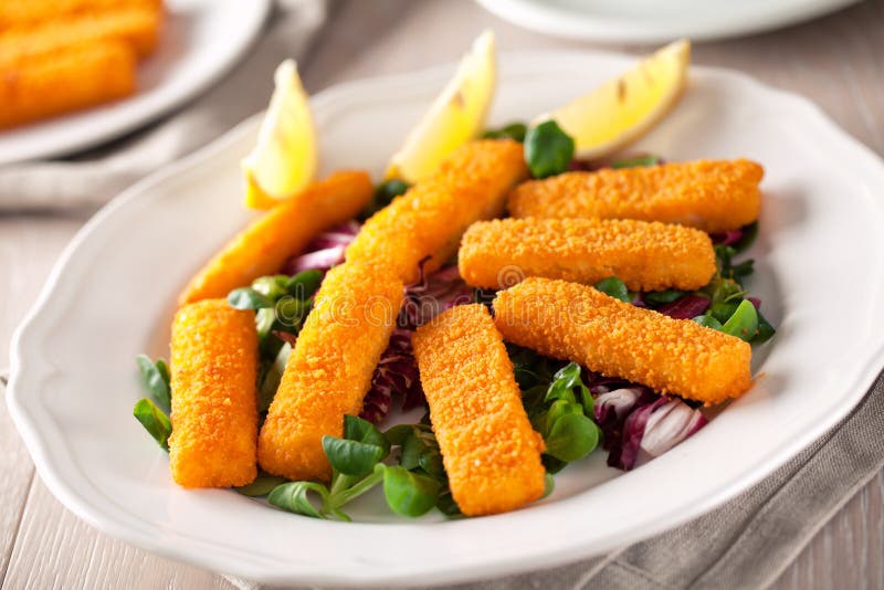 Fresh breaded fish fingers served with mixed salad. royalty free stock image