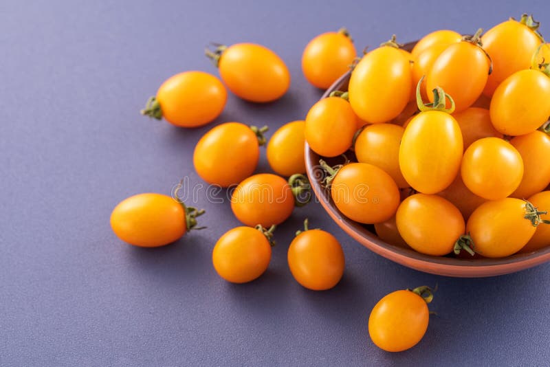 Fresh cherry tomatoes in a wooden bowl