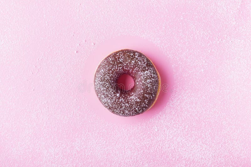 Fresh chocolate donut or doughnut decorated sugar powder on pink pastel table top view. Flat lay. royalty free stock photos Fresh chocolate donut or doughnut decorated sugar powder on pink pastel table top view. Flat lay. royalty free stock photos