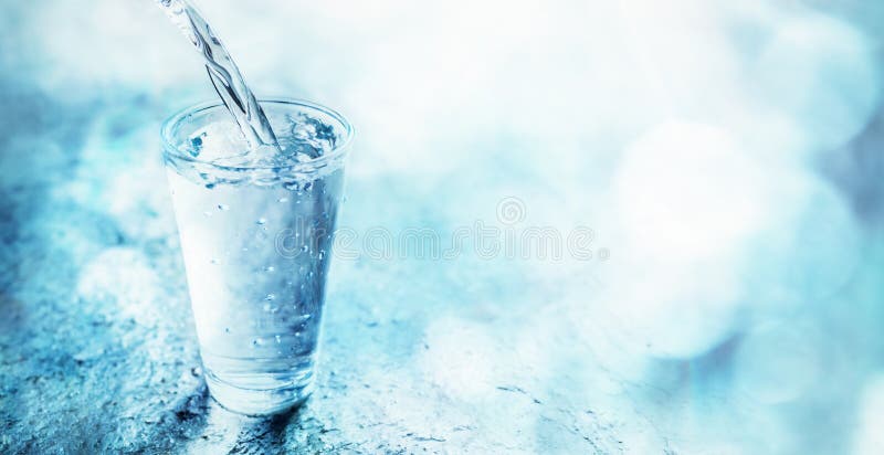 Fresh clean water pouring into a glass stock photo
