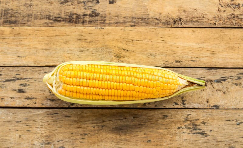 Fresh corn on wooden table background