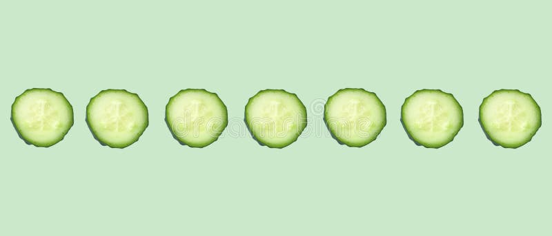 Fresh cucumber slices in a row on a mint background.