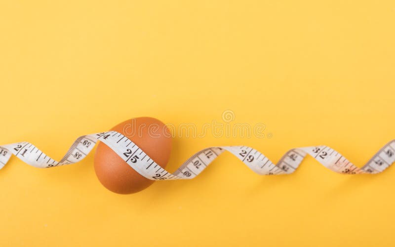 Fresh Egg and Measuring Tape on a Table Symbolize the Idea of Eating