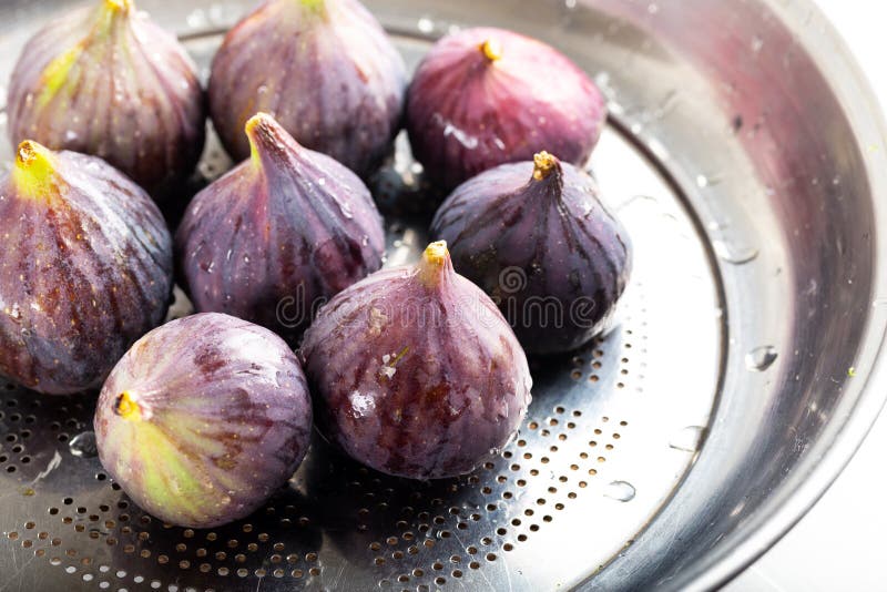 Fresh figs fruits inside metal colander on table stock image