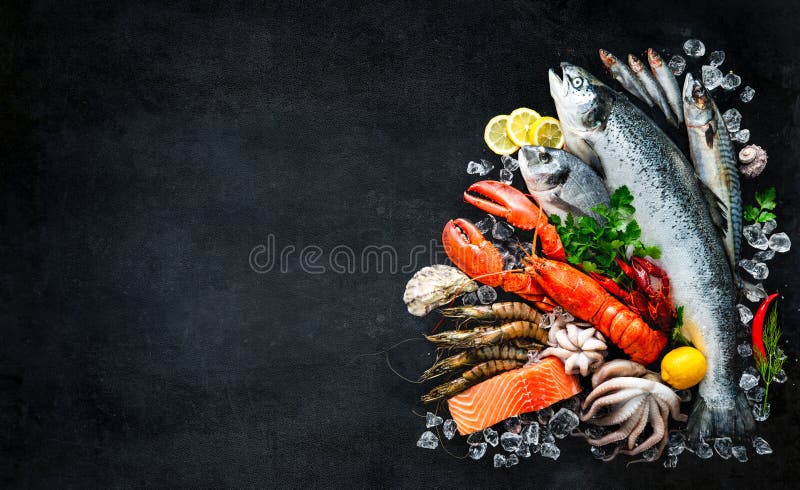 Fresh fish and seafood arrangement on black stone background