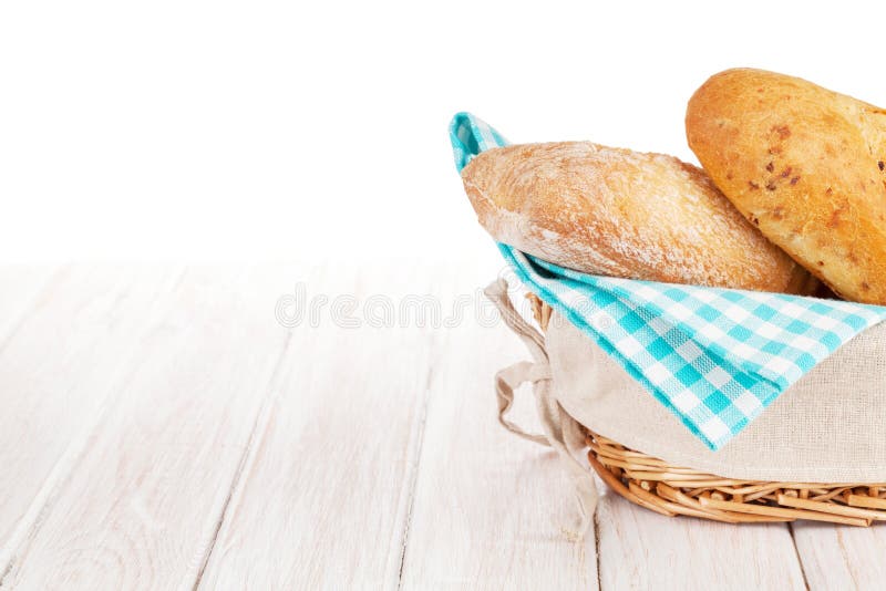 Fresh french bread in basket over white wooden table