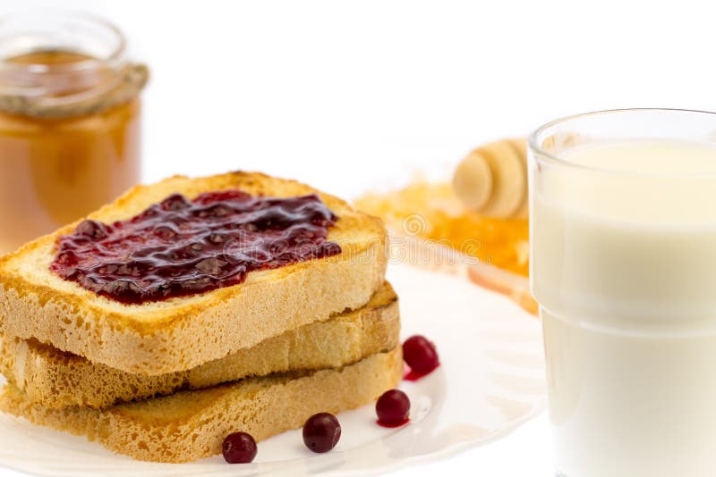 Fresh french toast with honey and jam on a white plate with berries on a white background.