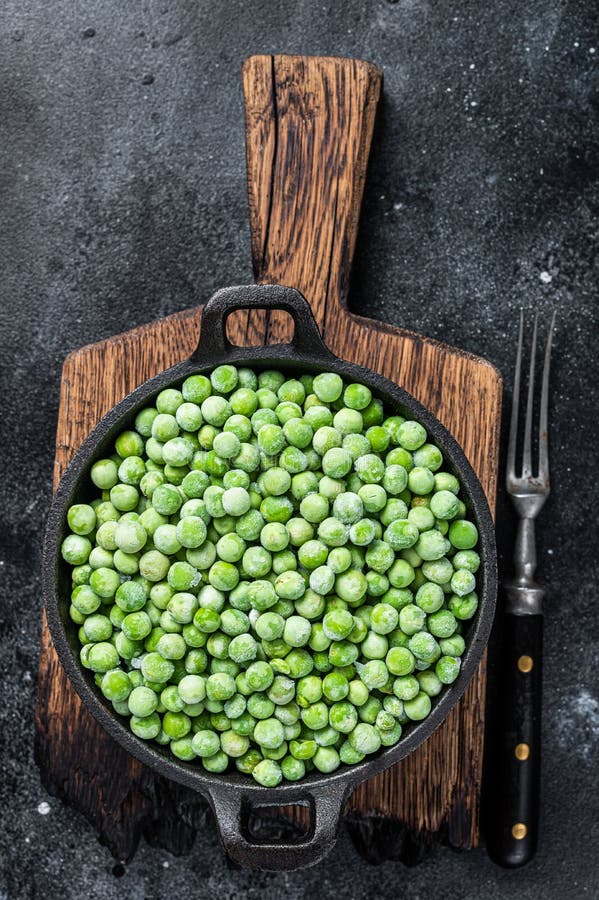 Fresh Frozen Green Peas in a Pan. Black Background Stock Photo Image