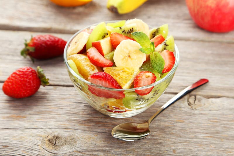 Fresh Fruit Salad in Bowl on Grey Wooden Background. Stock Photo