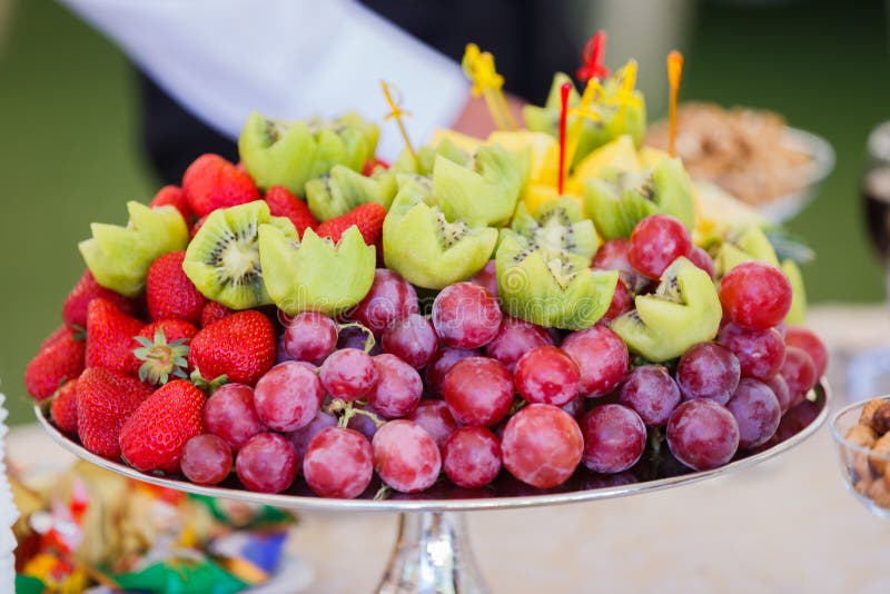 Fresh fruits on plate. Strawberries, kiwi, grapes on catering banquet table.
