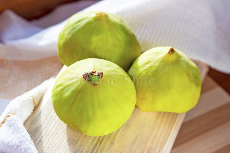 Fresh green fig fruit on the wooden board in the kitchen close up during the summer season. royalty free stock photos Fresh green fig fruit on the wooden board in the kitchen close up during the summer season. royalty free stock photos