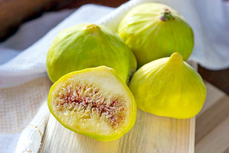 Fresh green fig fruit on the wooden board in the kitchen close up during the summer season. royalty free stock images Fresh green fig fruit on the wooden board in the kitchen close up during the summer season. royalty free stock images
