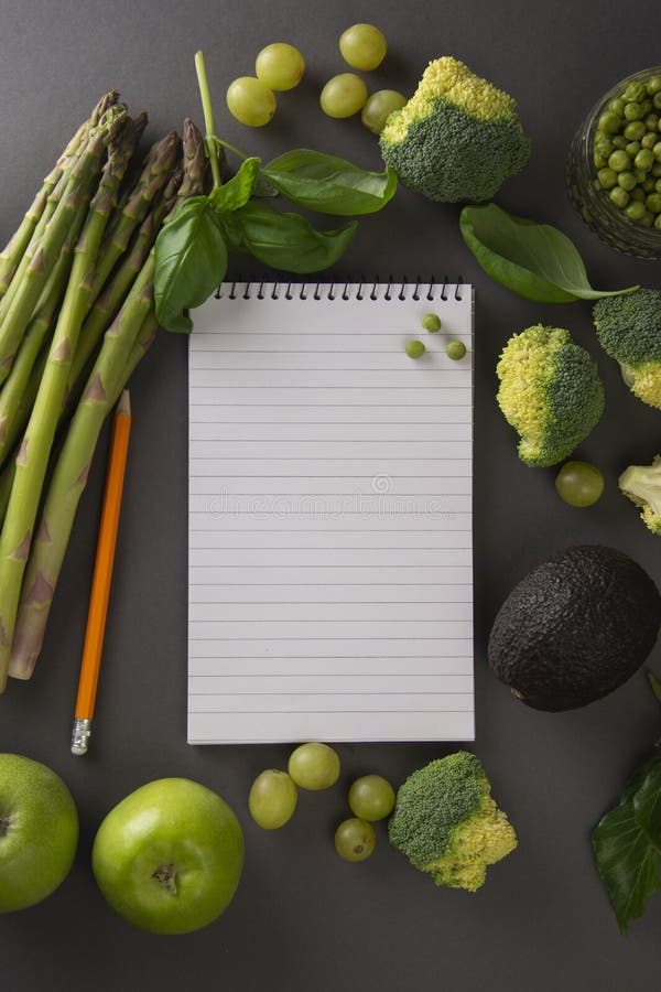 Fresh green vegetables and fruits on gray background and notebook for notes. Food blogging, food recipe. Space for text royalty free stock photos Fresh green vegetables and fruits on gray background and notebook for notes. Food blogging, food recipe. Space for text royalty free stock photos