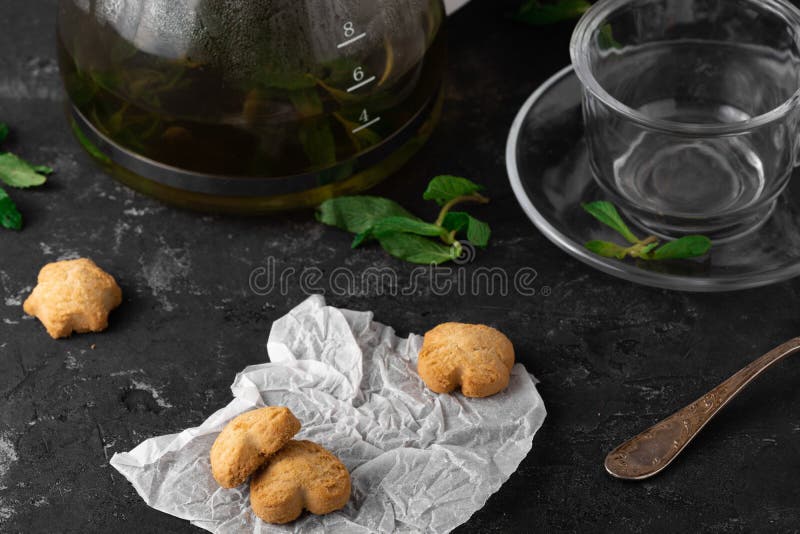 Fresh Homemade Cookies with Mint Tea and One Partly Eaten on Dark Stone Table with Copy Space Horizontal stock photos Fresh Homemade Cookies with Mint Tea and One Partly Eaten on Dark Stone Table with Copy Space Horizontal stock photos