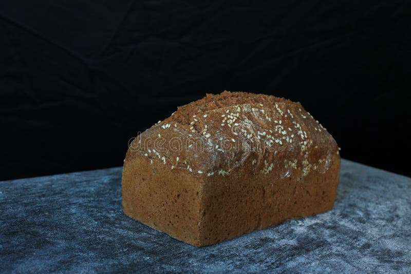 Fresh Homemade Rectangular Bread on a Dark Background. Mother Dough