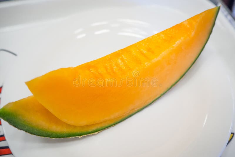 The Fresh Japanese Melons Sliced on White Plate Image Close Up. Stock