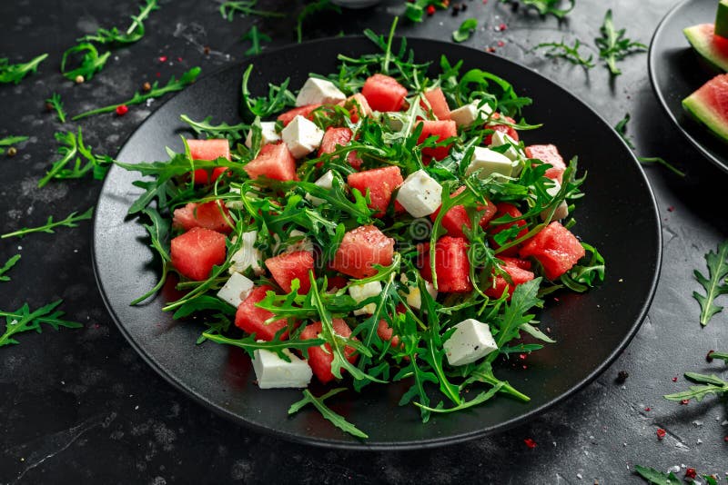 Fresh Juicy Watermelon arugula Feta salad with mint and orange, lemon dressing. summer dish. healthy food royalty free stock images Fresh Juicy Watermelon arugula Feta salad with mint and orange, lemon dressing. summer dish. healthy food royalty free stock images