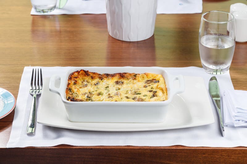Fresh Lasagna in a Baking Dish with Bread Basket. Stock Photo Image