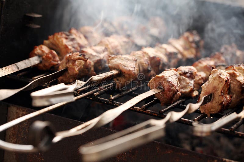 Fresh meat on a steel skewer in a smoke at brazier. Roasted skewer grill stock images, royalty-free photos and pictures