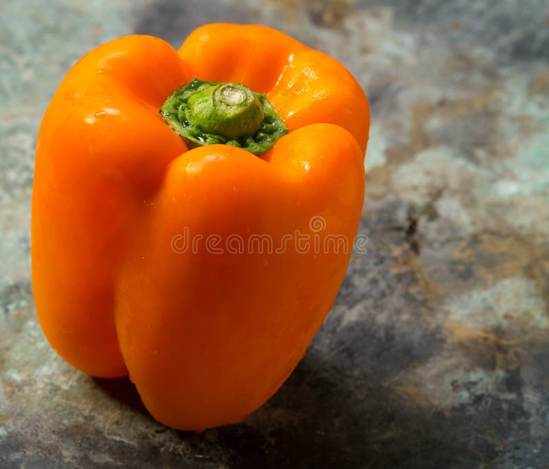 A beautiful bright orange bell pepper fresh from the garden. A beautiful bright orange bell pepper fresh from the garden.