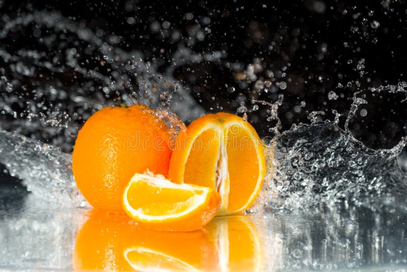 Fresh orange on black background with streaming water on it. Mir