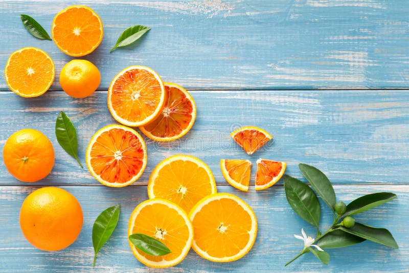 Fresh Orange Fruits and Slices on a Blue Wooden Background Stock Photo ...