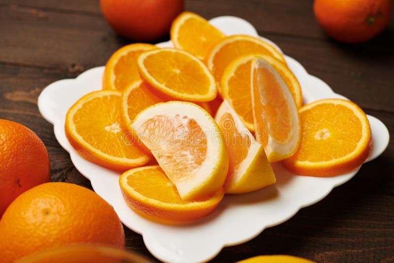 Fresh Orange Fruits Whole And Sliced On A Plate Dark Wooden Background