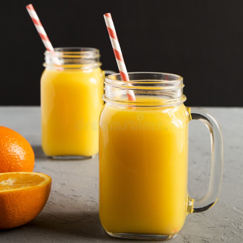 Fresh Orange Juice in Glass Jars Over White Wooden Background, Overhead