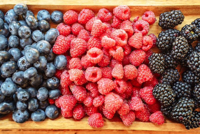 Fresh organic berries - blackberries, raspberries, blueberries on a wooden board stock photography Fresh organic berries - blackberries, raspberries, blueberries on a wooden board stock photography