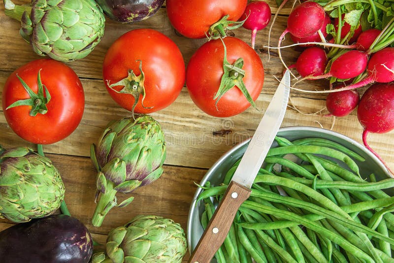 Fresh Organic Vegetables Artichokes Green Beans Tomatoes Red Radish Broccoli Eggplants on Weathered Wood Garden Kitchen Table
