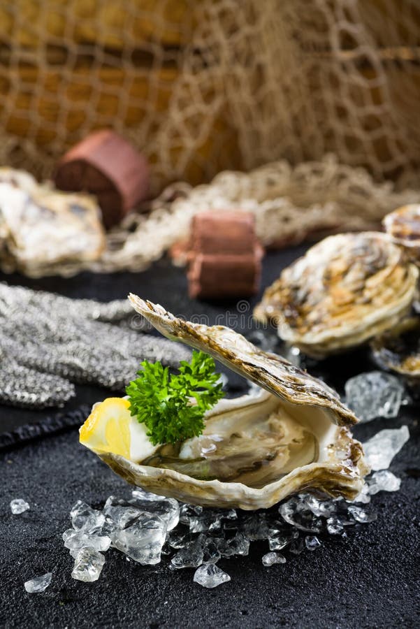 Fresh oyster on ice on a black stone table stock image